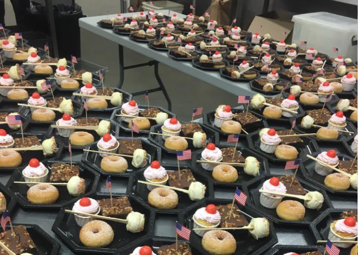 Buffet de desserts individuels avec donuts, gâteaux et brochettes sucrées préparés par Traiteur Péberat Cédril